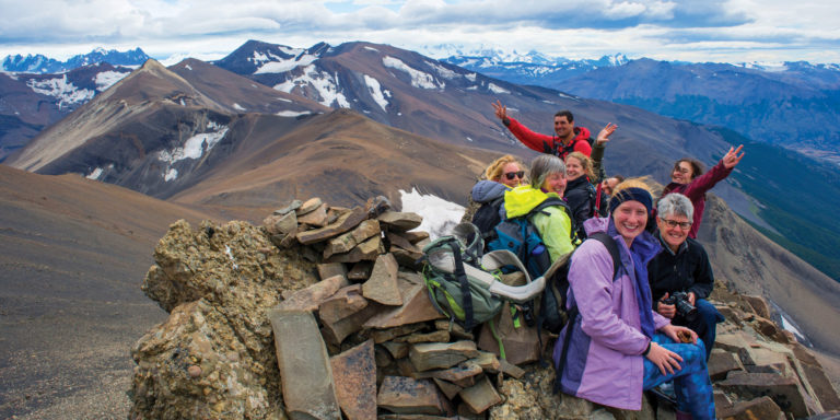 People smiling on top of the mountain in Patagonia. This is one of the best treks in South America