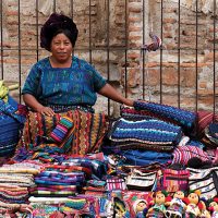 Lady selling textiles in Antigua Guatemala Contours Travel