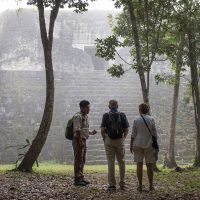 Tourists and guide building Uaxactun Guatemala Courtesy of Via Venture